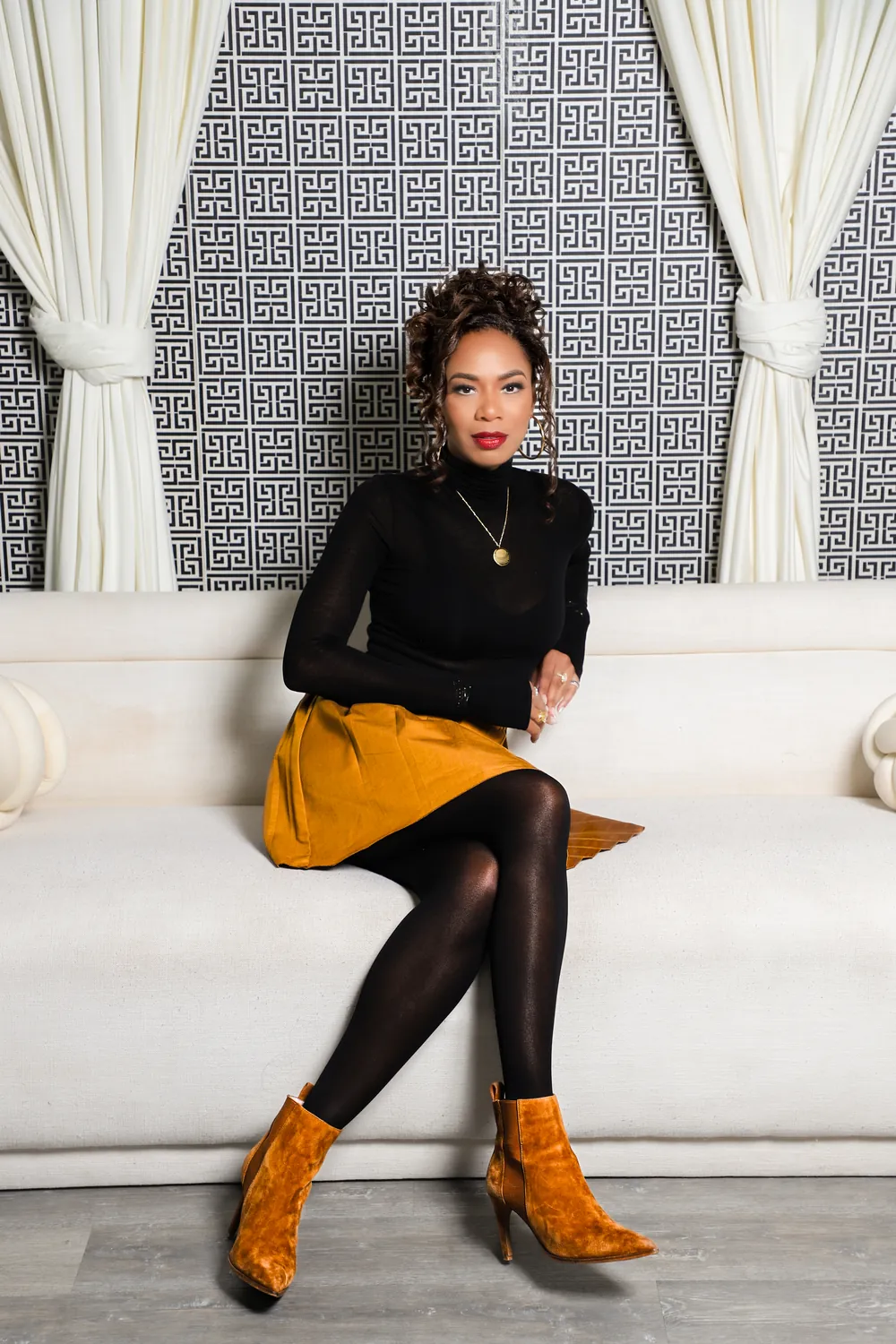 Damali Alexander seated on a cream sofa